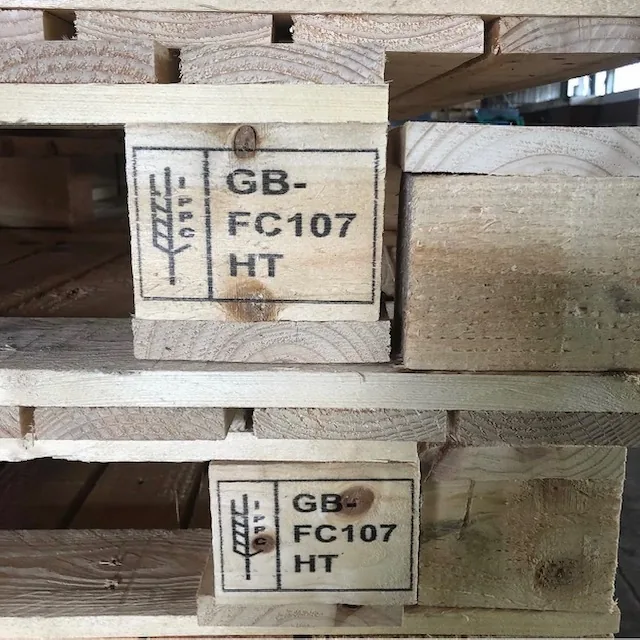 Close-up of GB FC107 HT markings on wooden pallet blocks