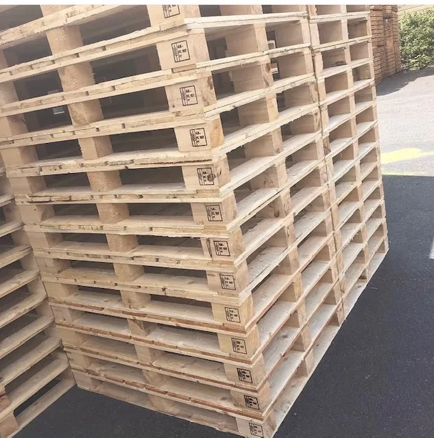 Wooden pallets stacked outdoors with heat-treatment markings